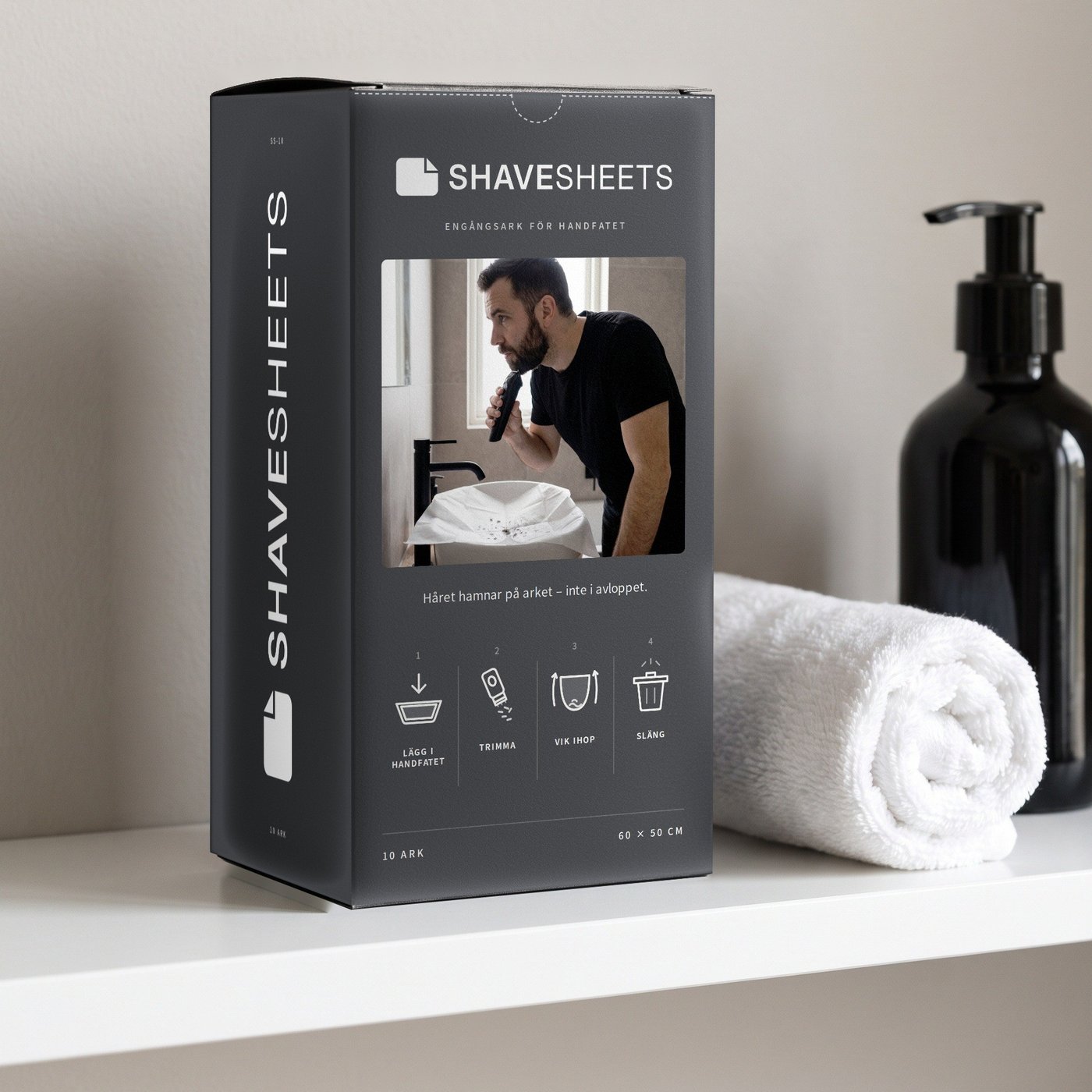 ShaveSheets-boxen står på en hylla i badrummet, bredvid en upprullad handduk och en tvålpump.